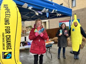 Fairtrade street stall with activists in front of it, one in a banana costume