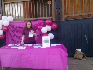 woman standing at stall with balloons in background